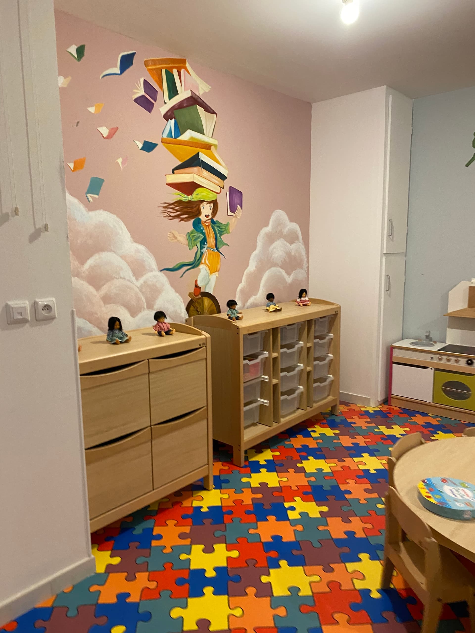 Petite fille qui lit dans un espace de lecture de la micro-crèche